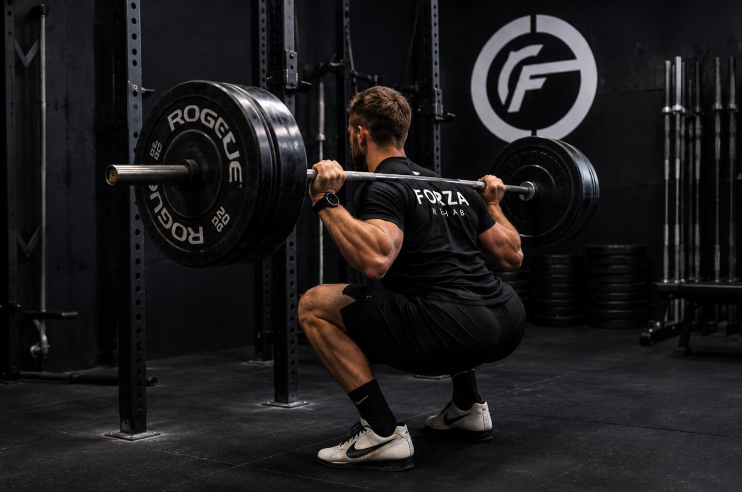 Man back squatting with barbell.